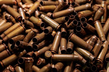 Makineli tüfek arka planında bir sürü fişek var.