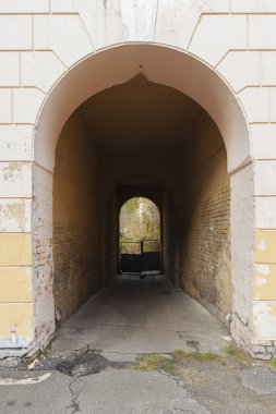 Eski bir şehir binasının arka bahçesine açılan koyu renkli tuğla kemerinden bak. Tarihi bir kentsel alana geleneksel mimari giriş