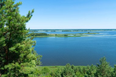 Geniş mavi bir nehrin manzarası. Küçük adaları ve berrak gökyüzünün altında yemyeşil ormanları var. Ukrayna 'nın güzel doğası yüksek bir bakış açısından
