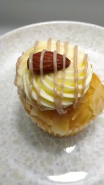 Tuzlu Karamelli Çiselemeli Kek 'in Yüksek Açılı Dikey Videosu Tereyağlı ve Badem Garnitürlü Tabakta Döndürme