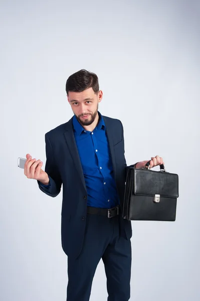 Young businessman with a briefcase and phone — Stock Photo, Image