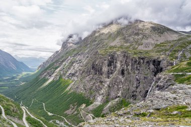 Derin vadi ve Storgrovfjellet Dağı manzaralı Trollstigen dağ yolunun keskin virajlarını keşfedin. Norveç 'in nefes kesici manzarasını gözler önüne serin.