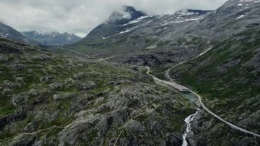 Norveç 'teki ünlü dolambaçlı dağ yolu Trol stijeni' nin hava manzarasını deneyin. Stigfossen şelalesinin, Alnestinden dağının ve Isterdalen vadisinin çarpıcı manzarası.