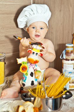 Küçük mutlu çocuk çocuk Şef mutfak olarak oynamak ve yemek