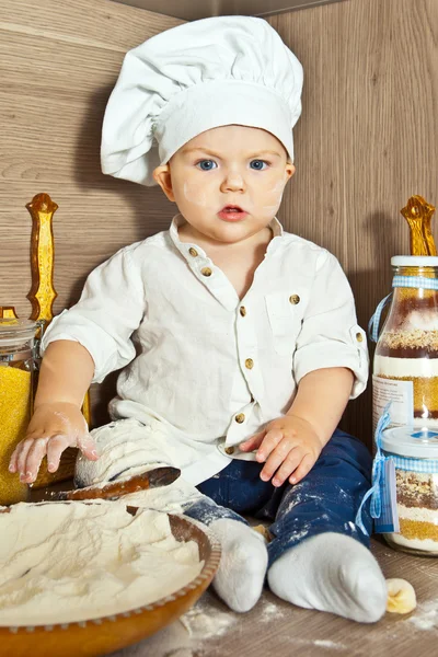 Little boy kid play in chef at kitchen and cook food — Stock Photo, Image