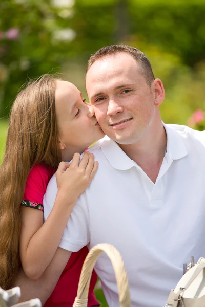 Hermoso padre joven y pequeña hija bonita abrazar al aire libre — Foto de Stock