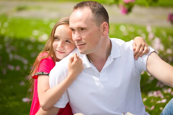 Hermoso padre joven y pequeña hija bonita abrazar al aire libre — Foto de Stock