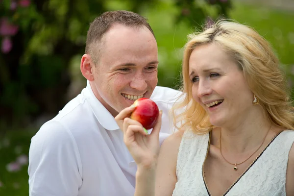 Piękna para z jabłkiem na piknik — Zdjęcie stockowe