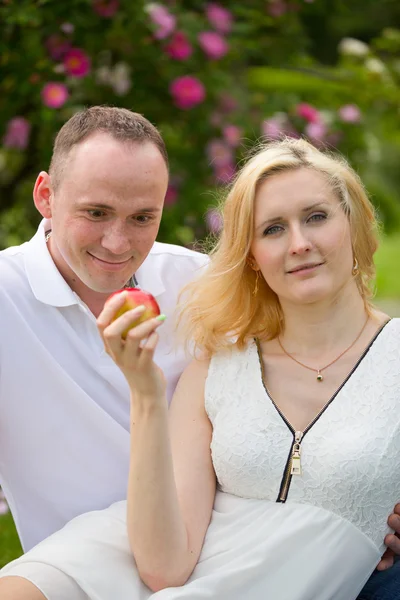 Piękna para z jabłkiem na piknik — Zdjęcie stockowe
