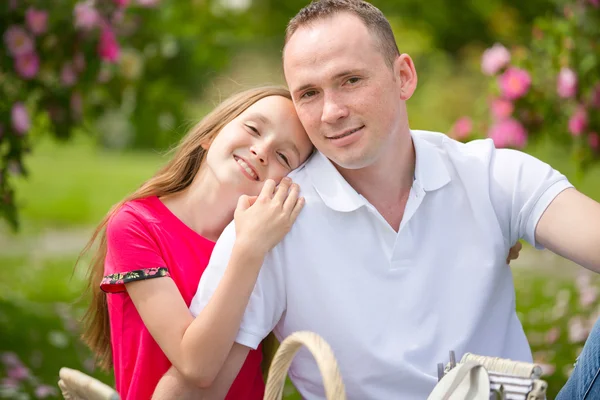 Hermoso padre joven y pequeña hija bonita abrazar al aire libre — Foto de Stock
