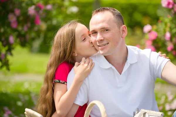 Hermoso padre joven y pequeña hija bonita abrazar al aire libre — Foto de Stock