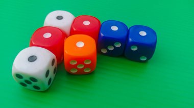 Pair of colorful dice placed on a bright green background.