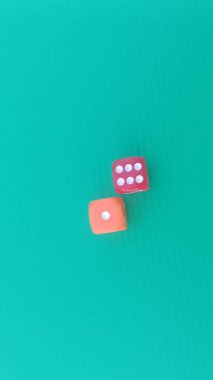 Pair of colorful dice placed on a bright green background.