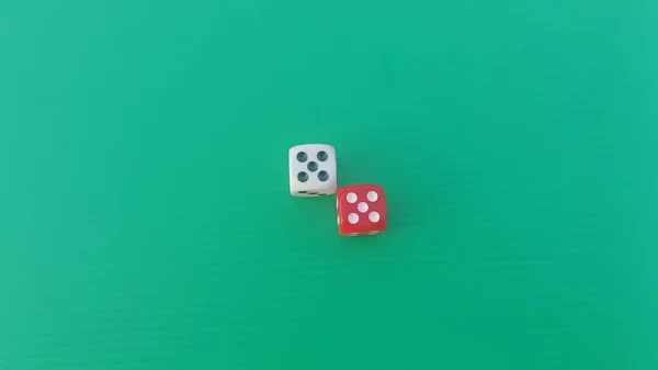 Pair of colorful dice placed on a bright green background.