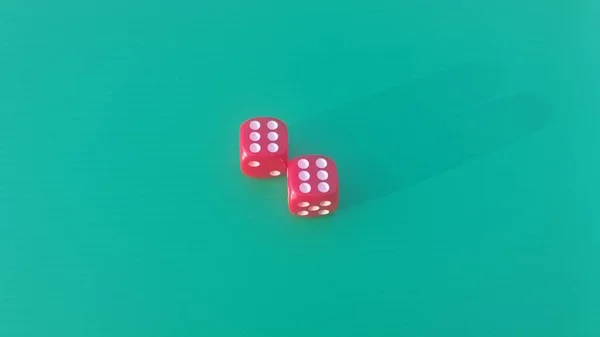 Pair of colorful dice placed on a bright green background.