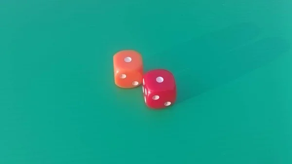 Pair of colorful dice placed on a bright green background.