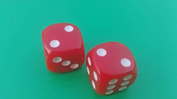 Pair of colorful dice placed on a bright green background.