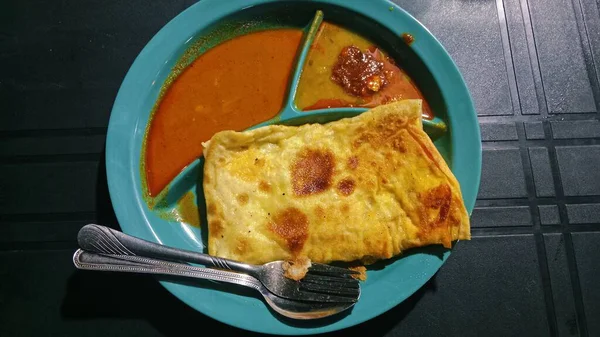 The scene captures a typical local breakfast setting with simple tableware and casual ambiance, representing Malaysian street food culture.