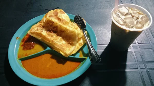 The scene captures a typical local breakfast setting with simple tableware and casual ambiance, representing Malaysian street food culture.