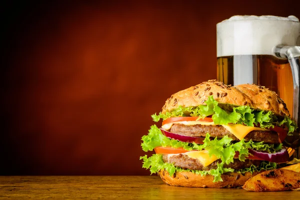 Hambúrguer e caneca de cerveja fria com espaço de cópia — Fotografia de Stock