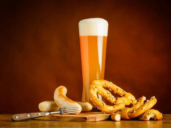 Piwo pszeniczne szkła z kiełbasą z grilla oraz Prezel — Zdjęcie stockowe