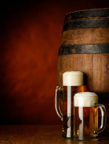 Tazas de cerveza sobre mesa de madera — Foto de Stock