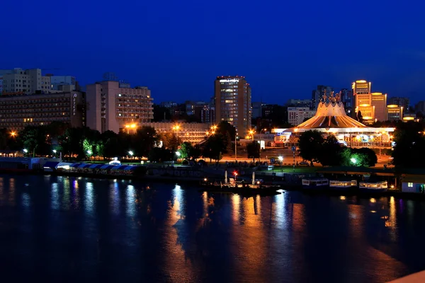 Zicht op de dijk van Dnipro uit de nieuwe brug 's nachts, lichten weerspiegeld in het water. — Stockfoto