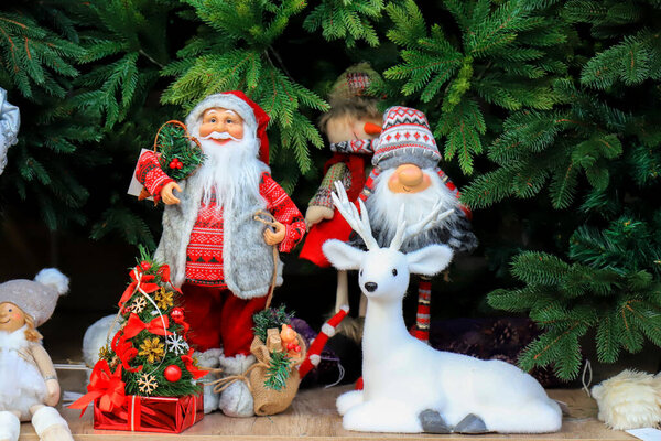 Новогодняя и рождественская елка, игрушки, украшения в магазине игрушек. Забавный Санта Клаус, снеговики, олени, куклы в супермаркете. Рождественская ярмарка в торговом центре