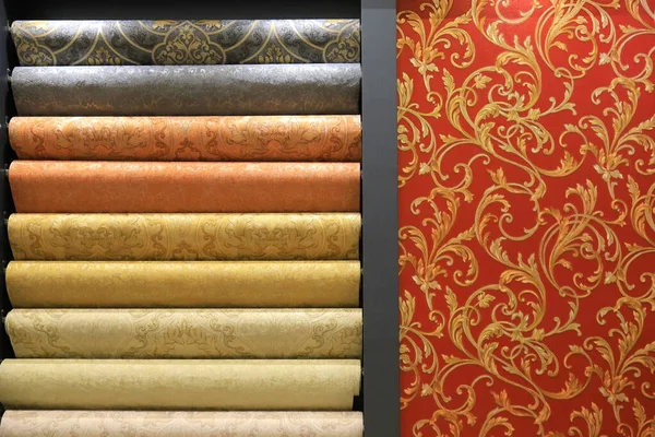 Rolls of vinyl quality wallpaper in a building supermarket, store, market. Dense wallpapers of different colors and patterns for walls, finishing materials for renovating interior.