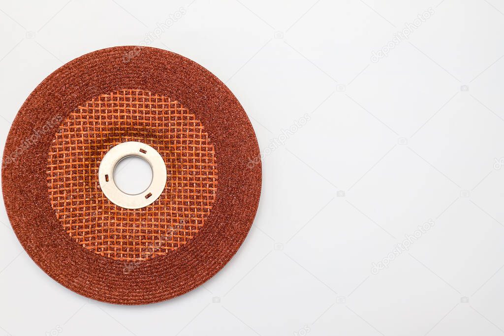 Abrasive wheel, grinding disc of orange, brown color, isolated on white background. Abrasive materials, discs, tools close-up