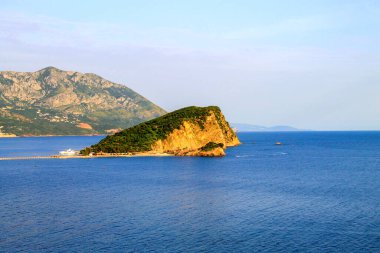 Budva 'daki Aziz Nicholas Adası. Karadağ. Adriyatik Denizi 'ndeki ada Budva' nın karşısındadır. Hawaii plajı, gün batımı.