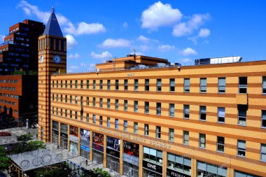 Modern güzel binalar, gökdelenler, büyük bir şehrin merkezindeki saat kulesi. Yaz ve baharda sarı ve kırmızı tuğlalı binalar. Dnepropetrovsk, Dnipro, Ukrayna, 30, 5 2020