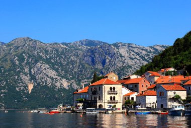 Karadağ 'ın Perast kentindeki eski tarihi binalar. Yazın yüksek dağların yakınında Kotor Körfezi 'nde güzel bir tatil köyü. Adriyatik Denizi, Karadağ
