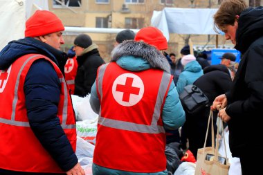 Dnipro Ukrayna, 01-15 2023. Kızıl Haç gönüllüleri, Rus roket saldırısından sonra yıkılmış evin yakınındaki yaralı insanlara yardım etmek için insani yardım dağıtıyor. Sağlık görevlisi üniformasında Kızıl Haç işareti. Ukrayna 'daki savaş.