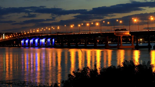 Akşam, su üzerinde ışıklar yansıyan köprü. — Stok fotoğraf
