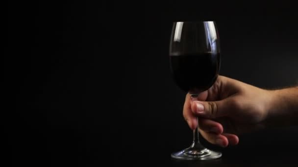 L'uomo beve vino rosso. Studio impostazione su uno sfondo nero — Video Stock