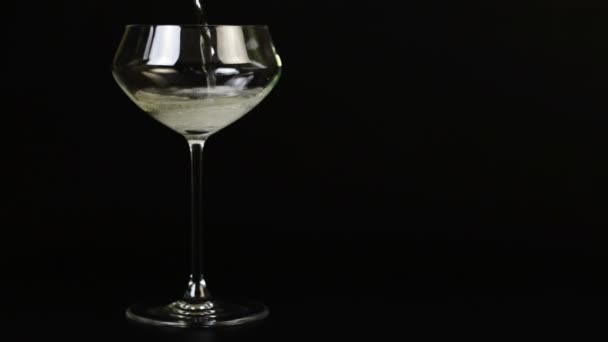 Lo champagne viene versato in un bicchiere su uno sfondo nero — Video Stock