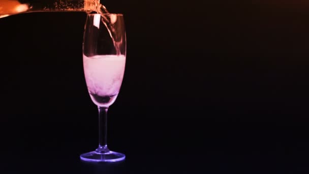 Champagne est versé dans un verre sur un fond noir — Video