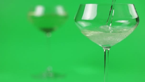 Lo champagne viene versato in un bicchiere su fondo verde — Video Stock