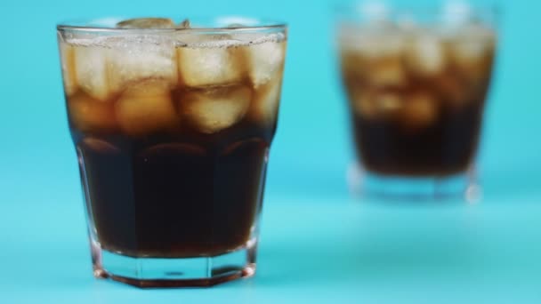 Refocusing glass of cola on a blue background — Stock Video