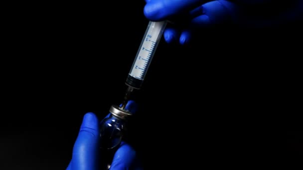 Doctor in blue gloves picking a medicine into the syringe — Stock Video