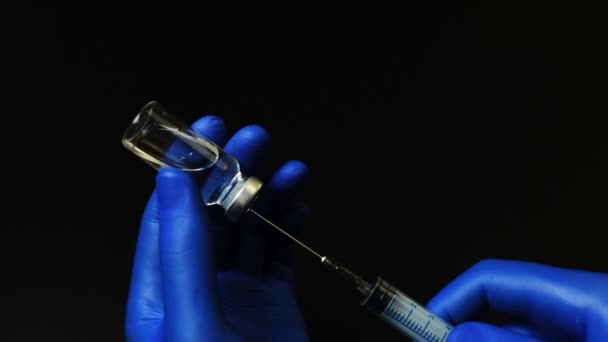 Doctor in blue gloves picking a medicine into the syringe — Stock Video