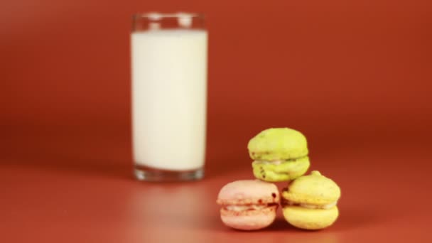 Glass of milk and macaroon on brown background — Stock Video