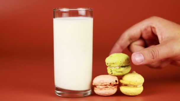 Glas Milch und Makronen auf braunem Hintergrund — Stockvideo