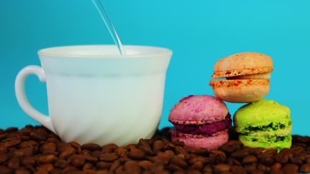 Taza de café sobre frijoles y macarrones sobre fondo azul . — Vídeo de stock