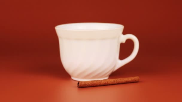 Cup coffee with cinnamon on brown background