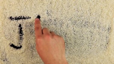 Erkekler el word Japonya pirinç yüzeyinde çizer.