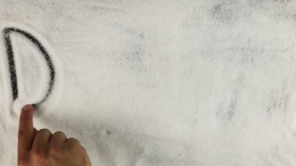 Мужчины рука рисует слово диабет на поверхности сахара — стоковое видео