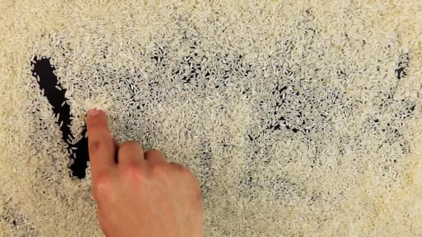 Мужчины рука рисует мир слова на поверхности риса — стоковое видео