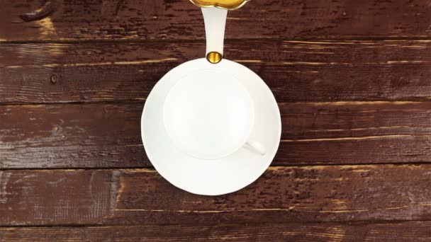 Tea being poured into glass tea cup on brown wooden table — Stock Video